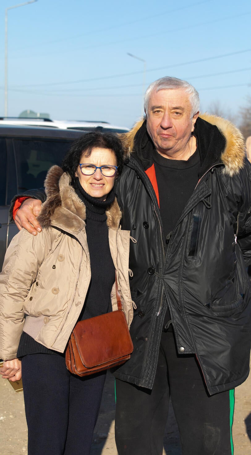 An older couple hold each other.