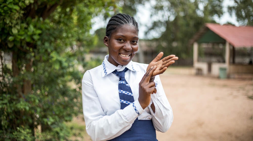 A young girl smiles looking towards the camera.