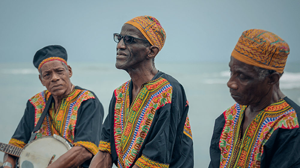 Three older men seated together. 