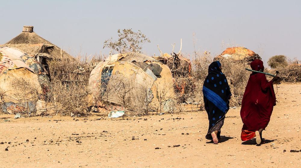 Dos mujeres caminan en un desierto.