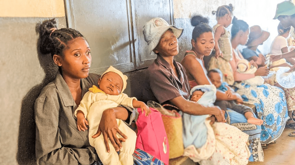 Georgette et son bébé, Freddy, attendent leur consultation au centre de santé de Maroalakely, où le personnel de l’UNFPA a également aidé la jeune femme à déclarer son enfant pour obtenir son certificat de naissance. © UNFPA Madagascar/Jean Martin