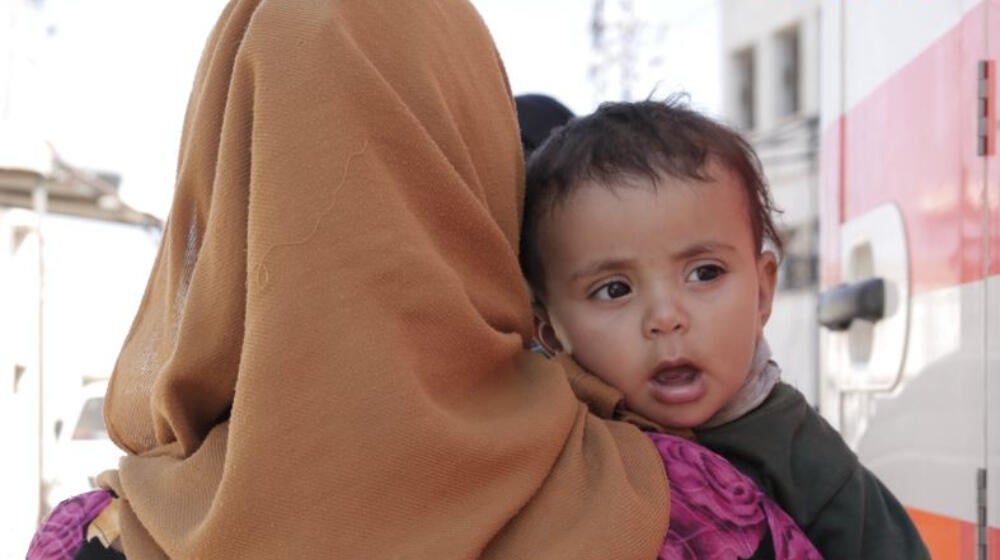 A woman holds a baby.